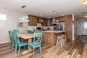 Una cocina moderna con armarios de madera, una isla central e iluminación colgante.