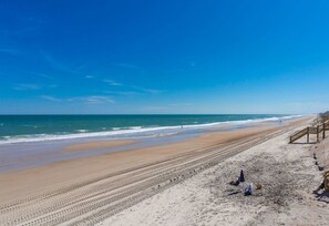 A beach with a wooden walkway and a few people. - Chez Nous - Classic 3BR Oceanfront Home with Modern Updates (Surf City)