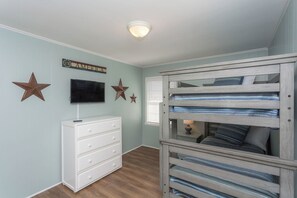 A bedroom with a bunk bed, a dresser, and wall decorations including stars and a sign. - Chez Nous - Classic 3BR Oceanfront Home with Modern Updates (Surf City)
