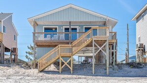 A beachfront house with a wooden deck, a staircase, and a balcony. - Chez Nous - Classic 3BR Oceanfront Home with Modern Updates (Surf City)