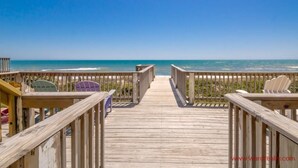 A wooden boardwalk leading to the beach with beach chairs and a wooden fence. - Dakota Dunes - Oceanfront!  Dog Friendly! (Surf City)