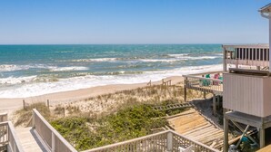 Une plage avec une structure en bois, comprenant une terrasse et un poste de surveillance pour les sauveteurs.