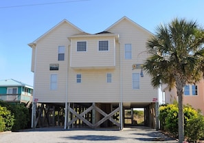 A two-story building with a flat roof, a covered front porch, and a visible garage entrance.