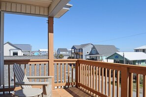 A wooden deck with a view of residential buildings.