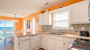 A kitchen with white cabinets, a double sink, and a toaster. - Fair Winds - Oceanfront (Surf City)