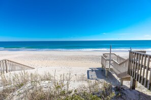 A beach with wooden boardwalks leading to the shore.