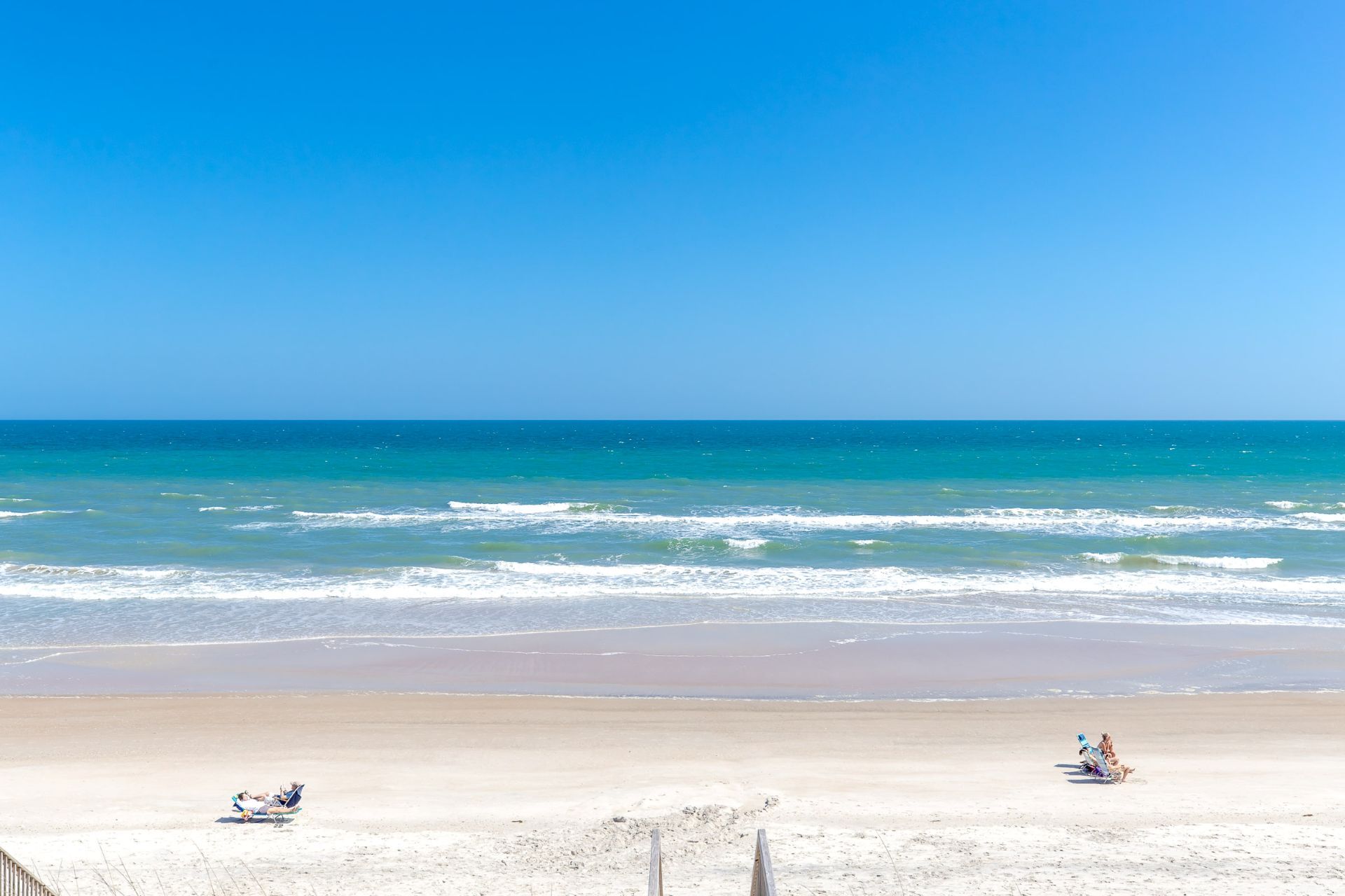 Ein Strand mit blauem Himmel und ruhiger See.