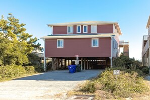 Une maison à deux étages avec un garage fermé et un petit porche.