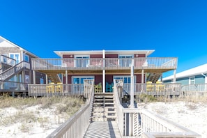 A multi-story beachfront building with balconies and a wooden walkway leading to the entrance. - Fins To The Right- Oceanfront 3 Bedroom (Surf City)