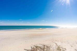 A beach with a clear sky and calm sea.