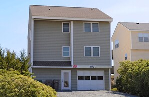 A multi-story residential building with a garage door, numbered 302, and a 'For Sale' sign. - Oceanic: Spacious 6BR oceanfront home (Surf City)