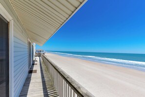 A beachfront property with a wooden deck overlooking the ocean.