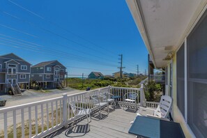 A balcony with outdoor furniture, a view of houses, and a clear sky. - Sea View - 3 bedroom, 2 bath cottage in Surf City!  Dog Friendly! (Surf City)