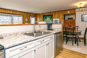 A compact kitchen with a sink, countertop, and cabinets.