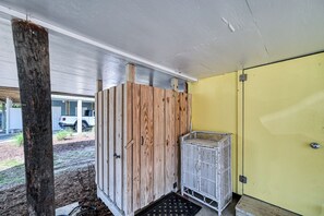 A room with a wooden partition, a metal cage, and a yellow door.