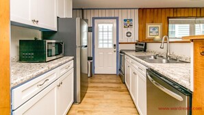 A kitchen with white cabinets, a microwave, a refrigerator, a sink, and a dishwasher. - Sea View - 3 bedroom, 2 bath cottage in Surf City!  Dog Friendly! (Surf City)