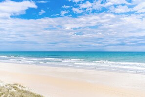 A beach with clear skies and calm waters. - Simple Pleasure Oceanfront in Surf City, NC—perfect for 15! (Surf City)