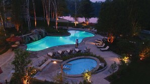 A resort pool area with a large pool, smaller circular pool, and lounge chairs. - Mont-Tremblant - Château Beauvallon-Two Bedroom Suite (Mont-Tremblant)