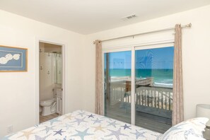Une chambre avec un lit, une salle de bain et un balcon donnant sur la mer.