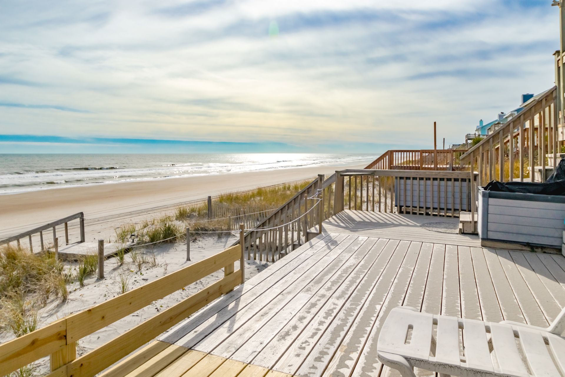 Une terrasse en bois offrant une vue sur la plage et l’océan.