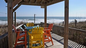 A wooden deck with a covered seating area overlooking the ocean. - Tumble Inn - Oceanfront home in Topsail Beach! Gazebo & Dog Friendly! (Topsail Beach)