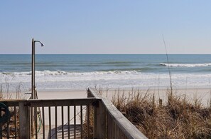 A wooden boardwalk leading to a beach with waves, a metal lamp post, and dry vegetation. - Tumble Inn - Oceanfront home in Topsail Beach! Gazebo & Dog Friendly! (Topsail Beach)