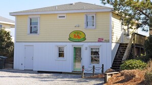 A two-story building with a yellow exterior and a sign indicating it is a Tumble Inn. - Tumble Inn - Oceanfront home in Topsail Beach! Gazebo & Dog Friendly! (Topsail Beach)