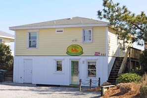 A two-story building with a yellow exterior and a sign indicating it is a Tumble Inn.