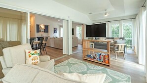 Un espacio habitable amplio con un sofá, una televisión y una mesa de centro de madera.