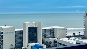 A coastal hotel with multiple buildings, including a prominent black glass structure, and a clear view of the ocean. - OD tower II #12, ocean view Fantastic condo + pool (Myrtle Beach)