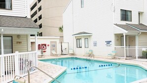 A pool area with a hot tub, lounge chairs, and a sign indicating no lifeguard on duty. - Ocean Dunes Villas #22, stay close to the ocean (Myrtle Beach)