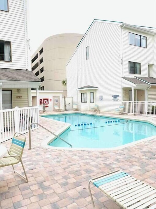 A swimming pool with a brick patio, white railings, and lounge chairs. - Ocean Dunes Villas #34, stay close to the beach (Myrtle Beach)