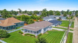 A residential neighborhood with single-family homes, a well-maintained lawn, and a white picket fence.