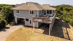 A two-story house with a deck and a covered outdoor area. - Modern Coastal Home, Close to Beach with Pool, Spa (Kitty Hawk)