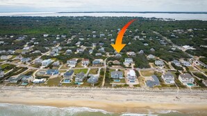 An aerial view of a coastal residential area with houses, a beach, and a large body of water. - Modern Coastal Home, Close to Beach with Pool, Spa (Kitty Hawk)