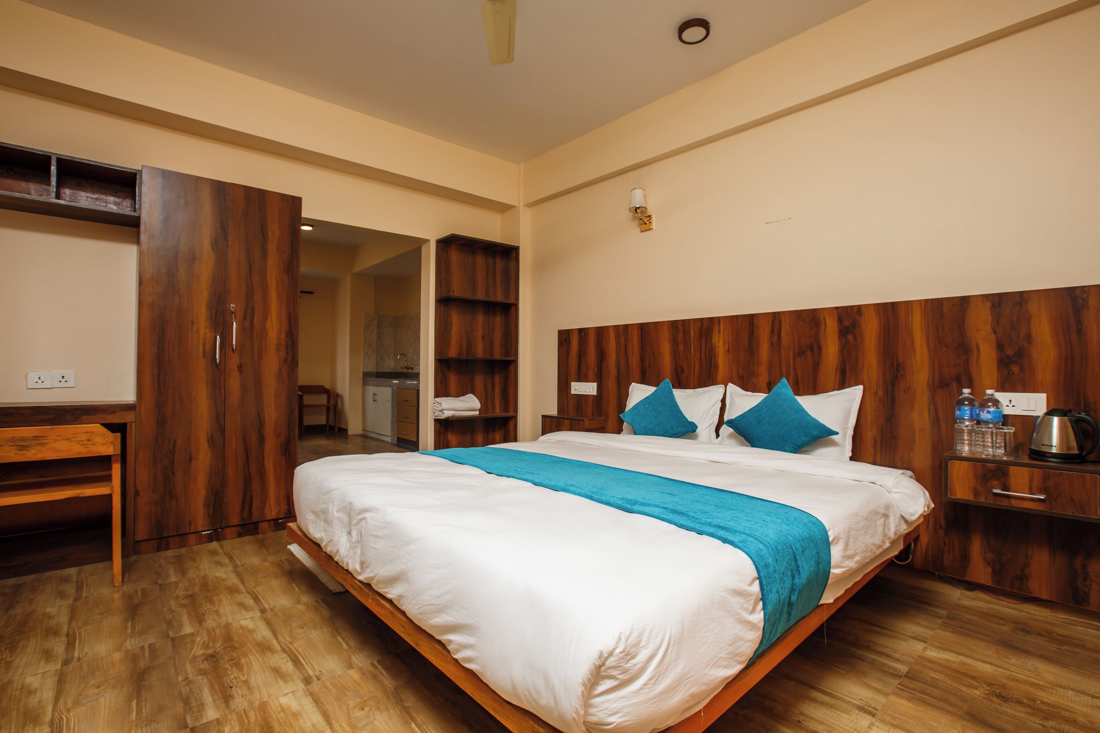A bedroom with a wooden bed, a desk, and a wardrobe.