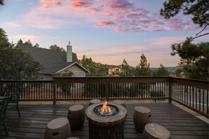 Une terrasse dotée d’un foyer extérieur, de sièges et offrant une vue sur le paysage environnant.