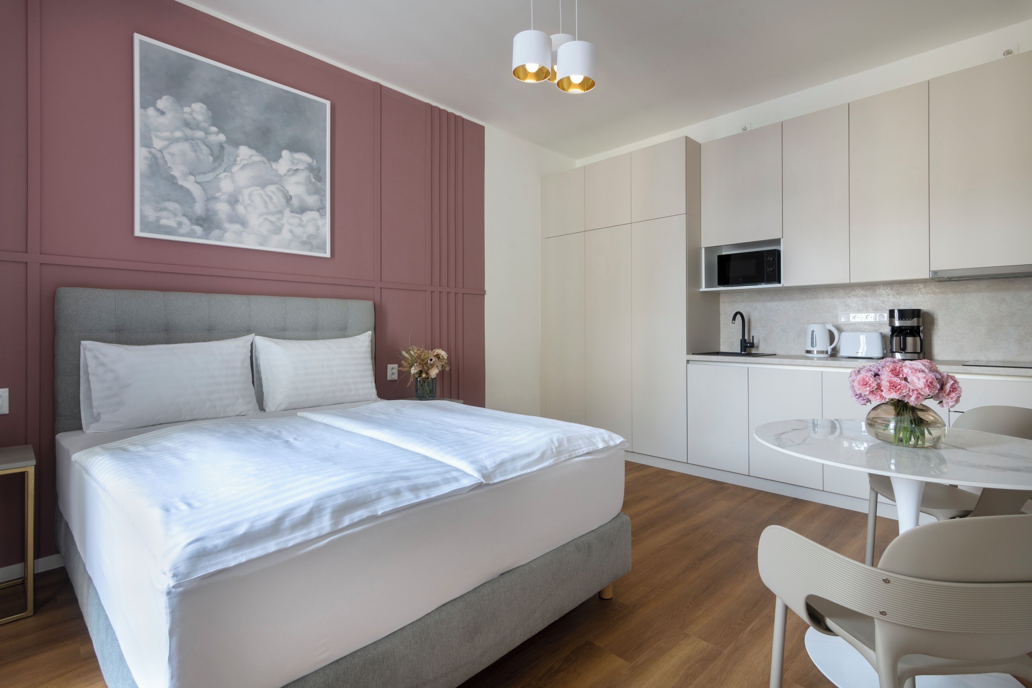 A modern bedroom with a bed, bedside table, and a painting on the wall.