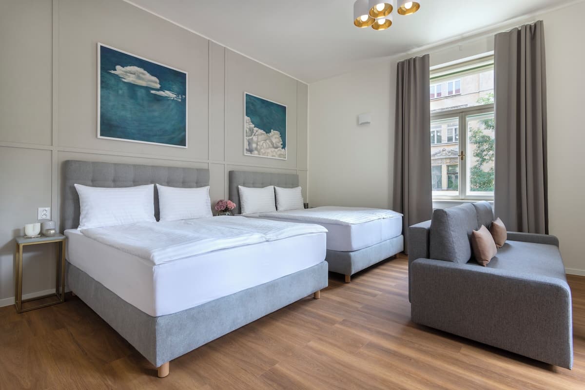 Ein modernes Hotelzimmer mit einem großen Bett, einer Sitzecke und Blick auf die Stadt.