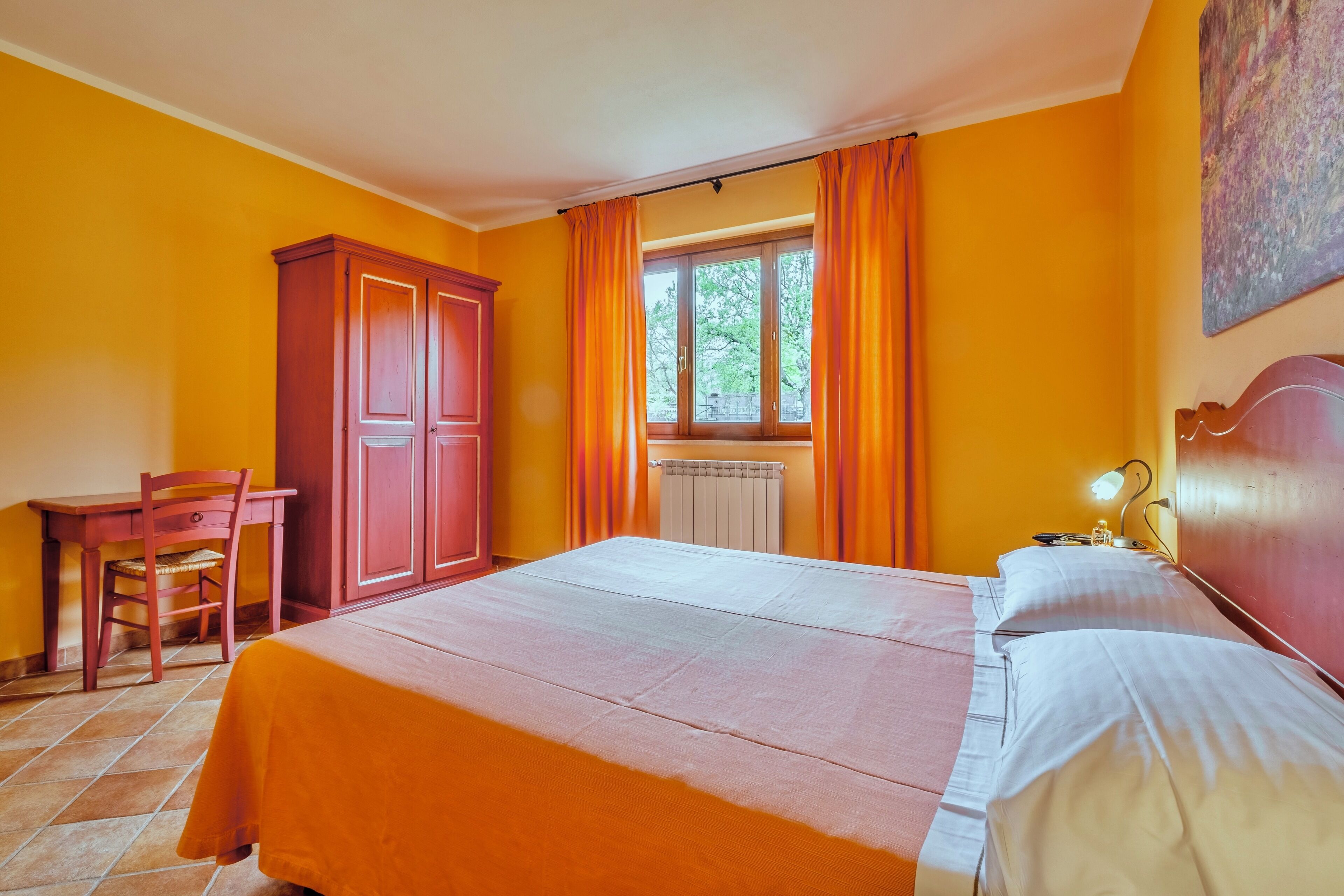 A room with a bed, a desk, and a chair.