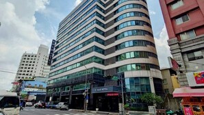 Un hotel moderno con fachada curva, varios pisos y grandes ventanales.