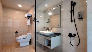 Un baño moderno con inodoro, lavamanos y ducha.