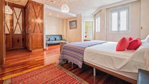 A bedroom with a bed, wooden wardrobe, and a patterned rug. - Solaga - Emma (Málaga)
