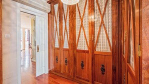 A hallway with wooden doors and a ceiling fan. - Solaga - Emma (Málaga)