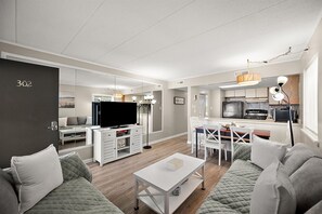 A modern living room with a sofa, a coffee table, and a TV.