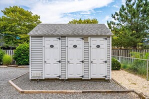 A two-car garage with a gravel driveway and a wooden fence in the background.
