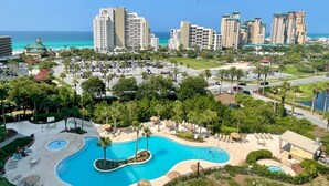 A resort with a large pool, palm trees, and high-rise buildings in the background. - Best views and close to the beach! 7801 L1 (Miramar Beach)