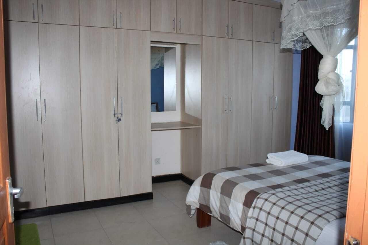 Un dormitorio con cama, armario y espejo.