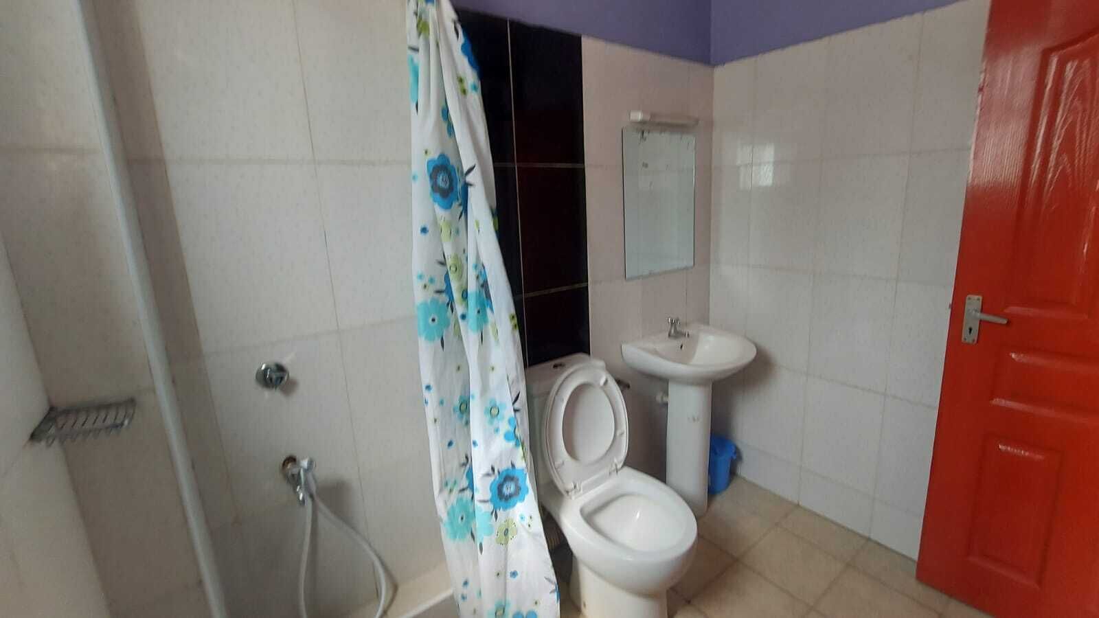 A bathroom with a toilet, sink, and shower.