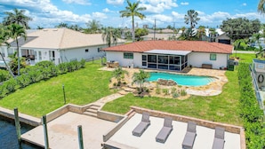 Una propiedad residencial con piscina, muelle y césped bien cuidado.